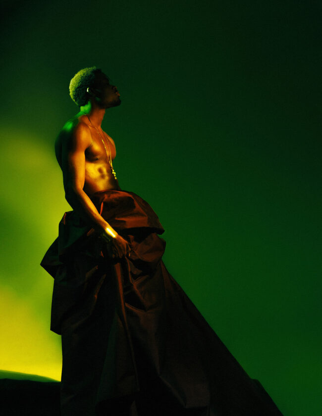 Male subject wearing dress looking afar