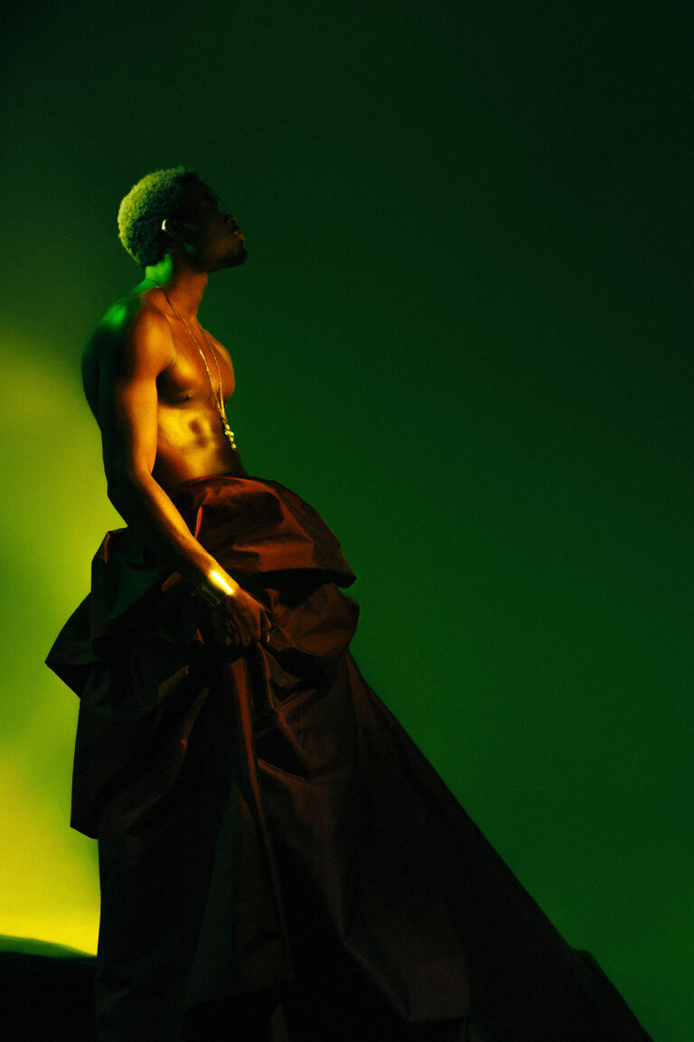 Male subject wearing dress looking afar