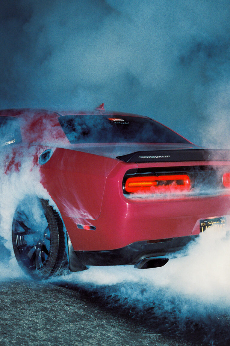 A corner shot of a car smoking at night.