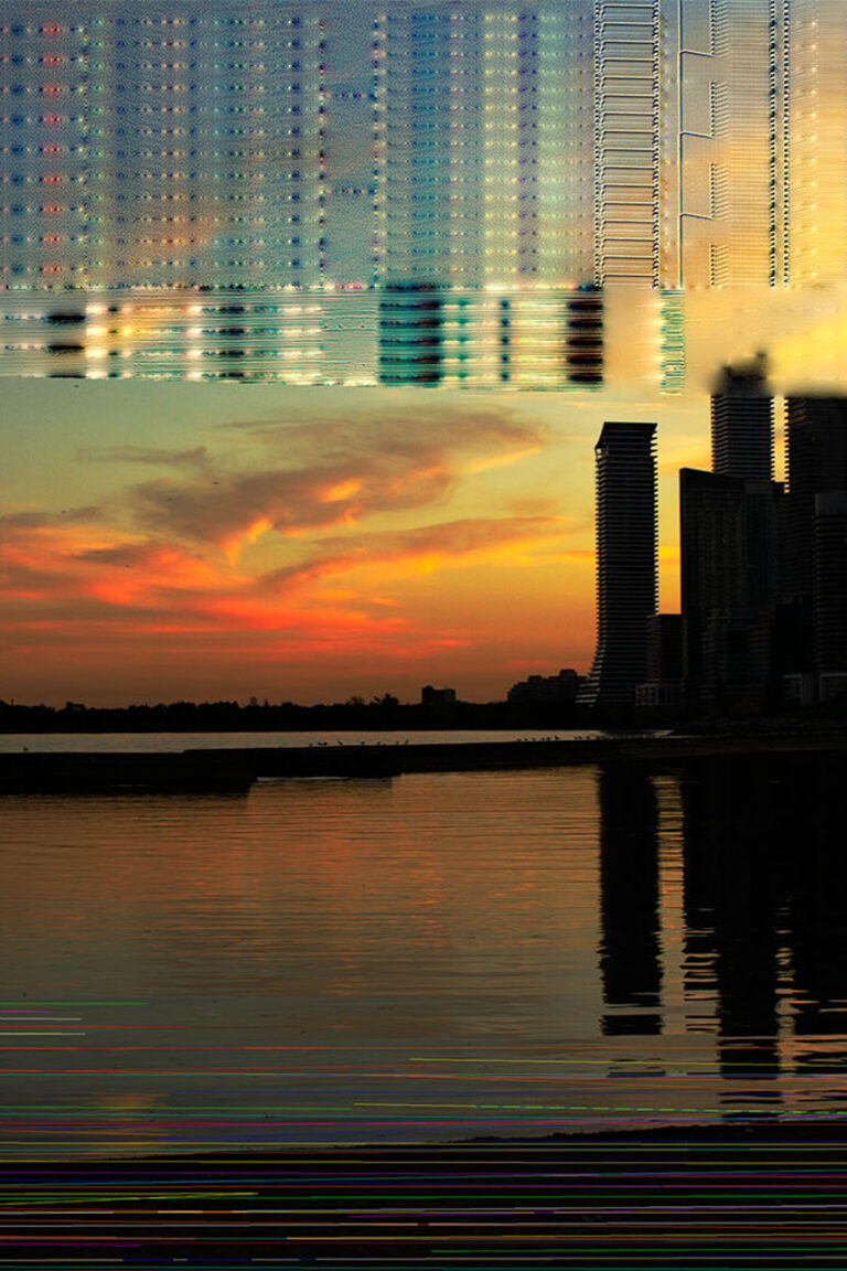 This photo consists of a skyline view of a city during sunset but is distorted by a digital glitch effect over top. The sky is a warm blue, orange, and yellow and the glitch is multicolored.