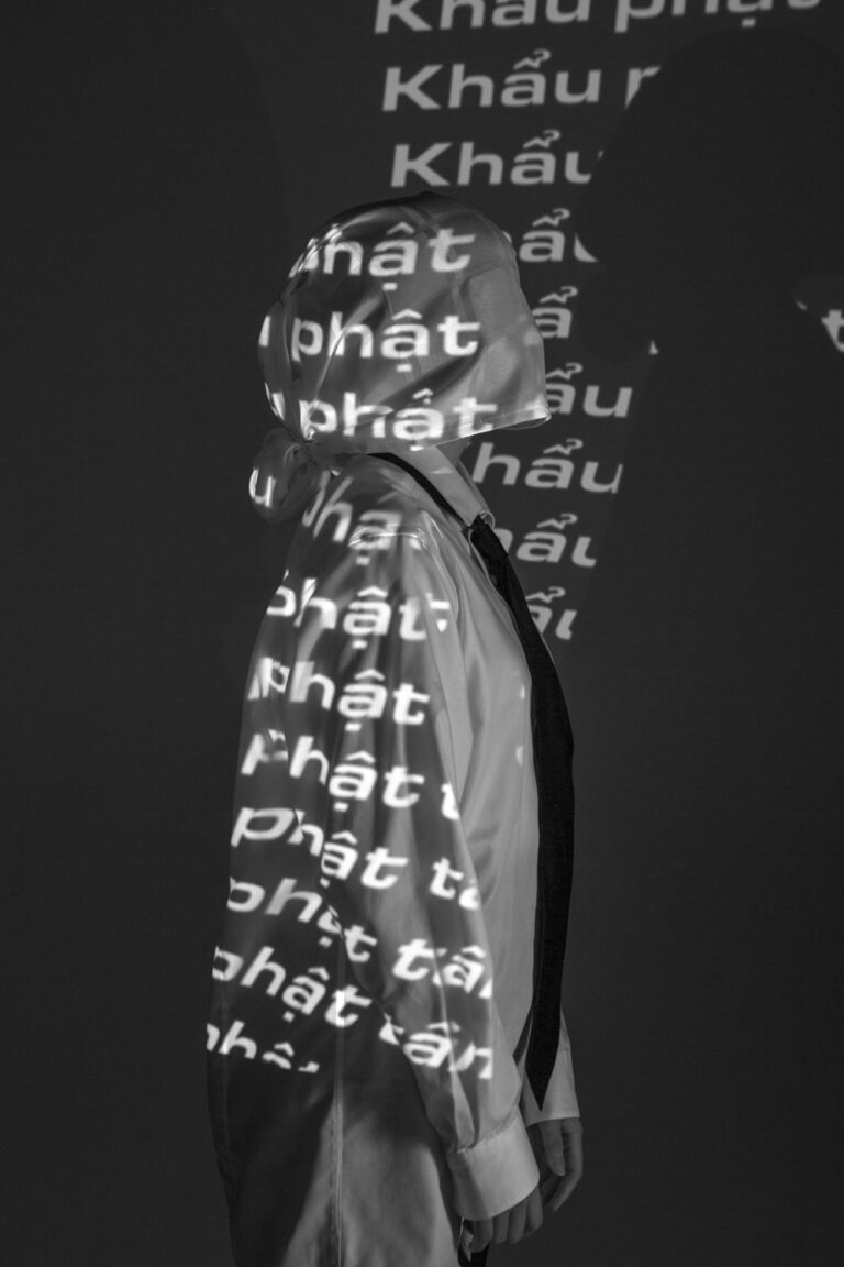 A profile of a white masked person, with words being projected onto them
