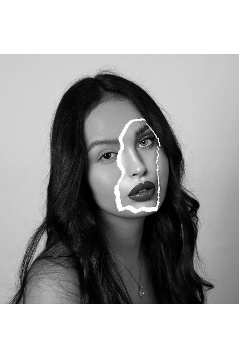 This photo is a portrait of a woman with no-makeup and black hair with a paper patch of another woman’s face on top of hers. This woman appears to be wearing make-up and is only shown as a torn piece of paper covering a part of the first woman’s face.