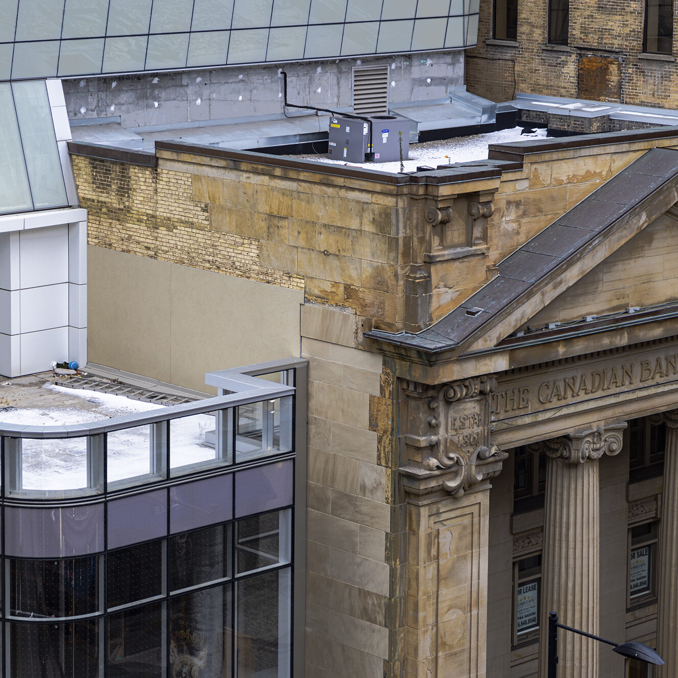 : In the middle is a beige brick building with tree branches at the bottom of the photo.