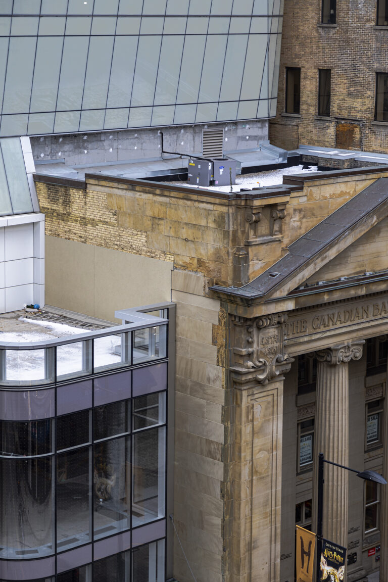 : In the middle is a beige brick building with tree branches at the bottom of the photo.