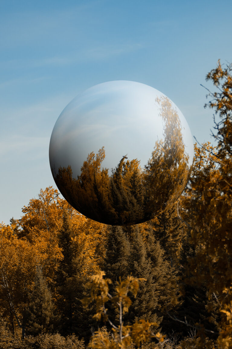 Landscape image of autumn trees and blue sky with a sphere floating in the middle.