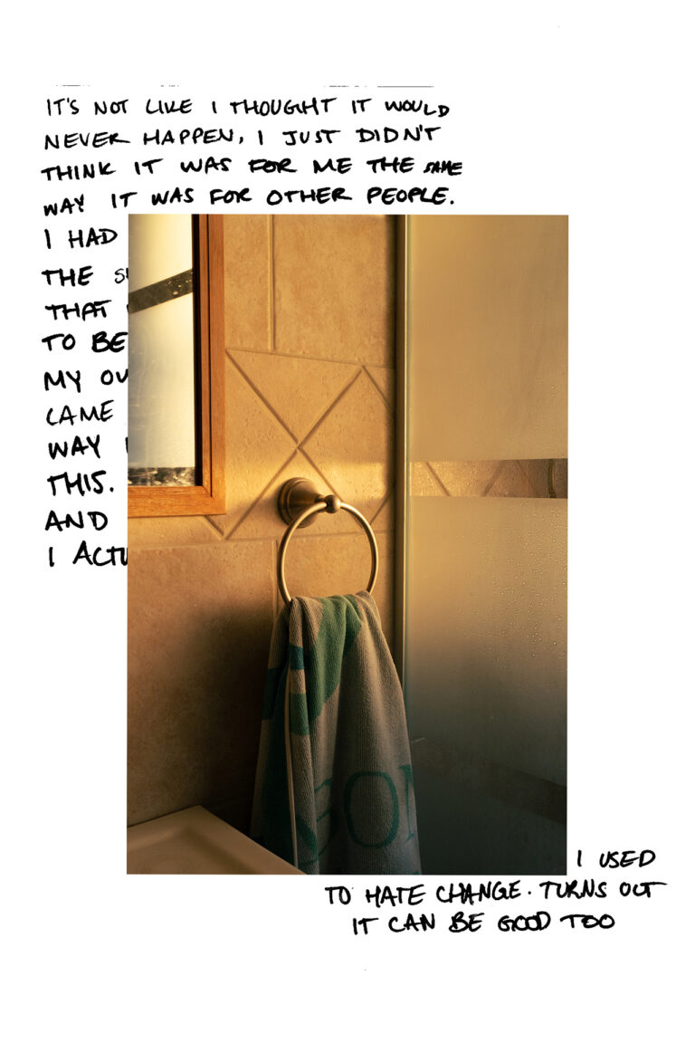 A photograph of a towel hung on a hook next to a shower in a bathroom, warm toned from the sunset at dusk. The image is placed over handwritten text in the top left and bottom right corners, covering most of it. The visible text reads "It's not like I thought it would never happen, I just didn't think it was for me the same way it was for other people... I used to hate change. Turns out it can be good too" in all capital letters.
