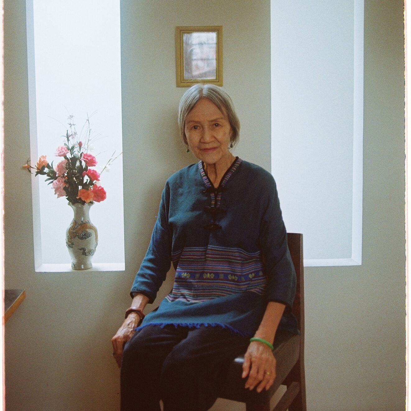 Hoa An elder Vietnamese woman sits and poses for the photograph by her alter.