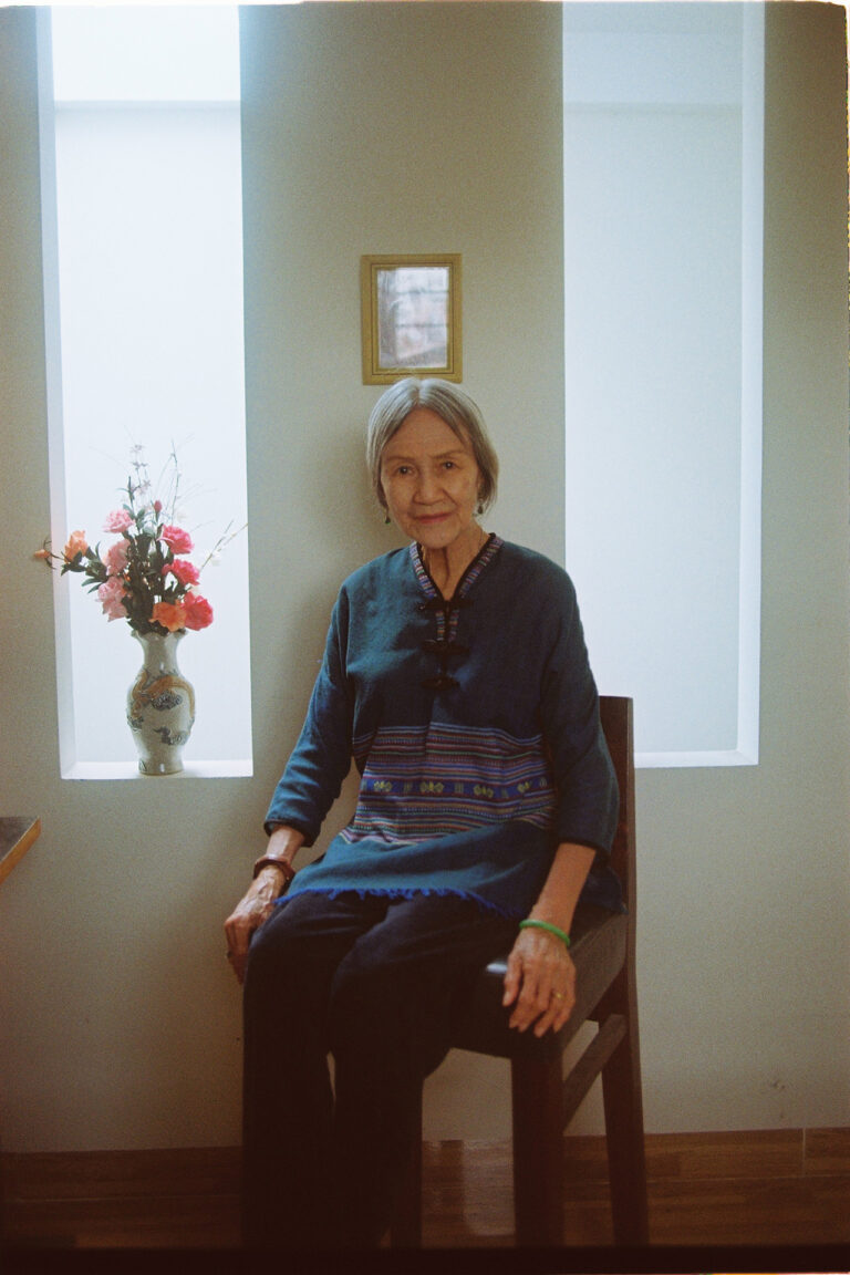 Hoa An elder Vietnamese woman sits and poses for the photograph by her alter.