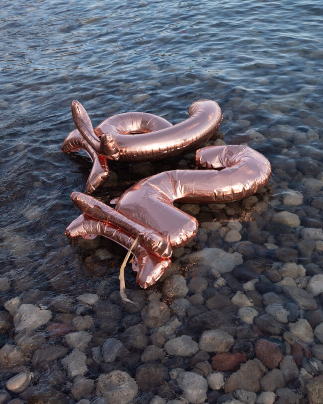 Shot of a 2 and a 6 balloon floating in water.