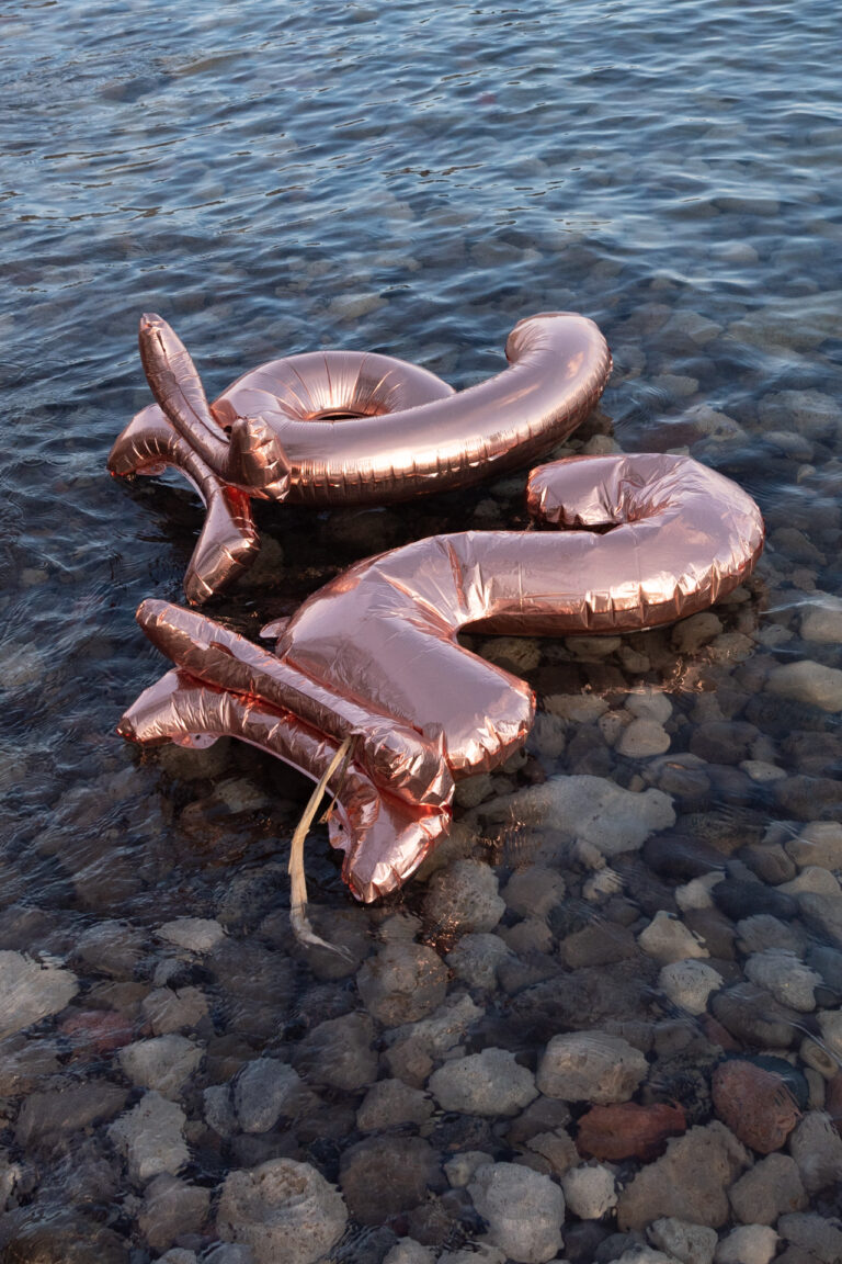 Shot of a 2 and a 6 balloon floating in water.